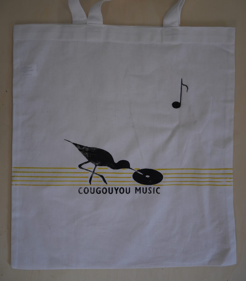 Tote bag decorated with the Cougouyou bird standing on a stave.